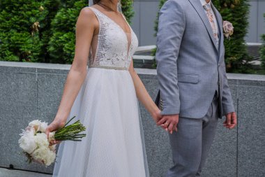 Gelin ve damat ofis binasının yakınında bir arada duruyor.