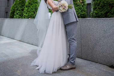 Gelin ve damat ofis binasının yakınında bir arada duruyor.