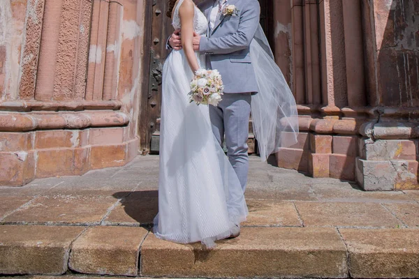 Nevěsta a ženich spolu stojí nedaleko kostela — Stock fotografie