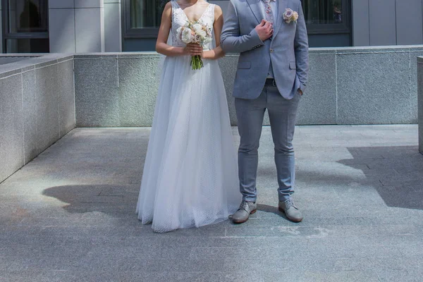 The bride and groom are standing together near the office building. — Stock Photo, Image