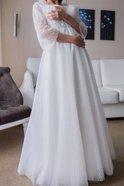 Mariée en peignoir tenant une robe de mariée — Photo