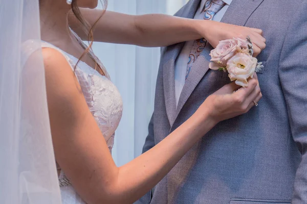 A noiva está vestindo o boutonniere — Fotografia de Stock