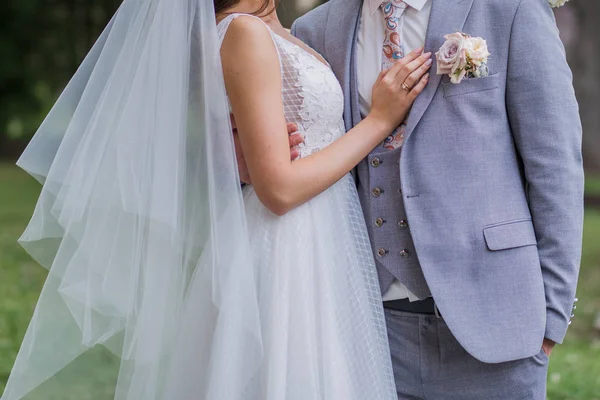 Жених и невеста стоят вместе в объятиях в парке — стоковое фото