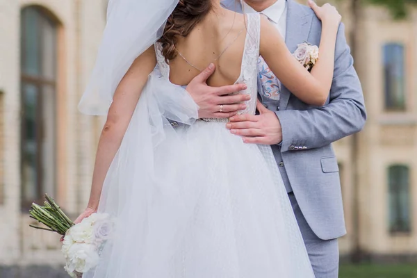 De bruid en bruidegom staan samen in een omhelzing in het Park — Stockfoto