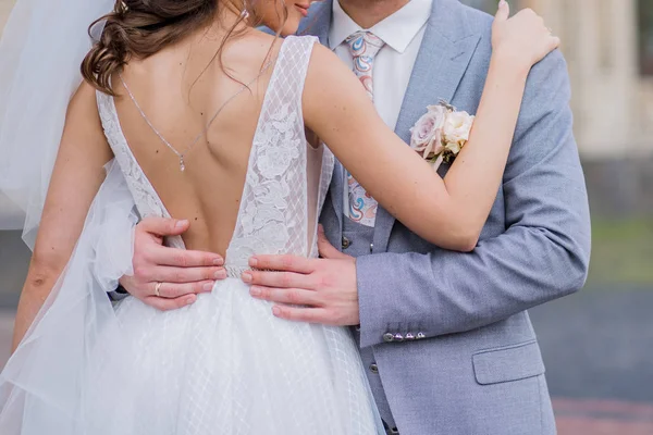 The bride and groom stand together in an embrace in the park — Stock Photo, Image