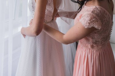 pembe elbisenin nedimesi bir ağırlıksız gelinlik koyar