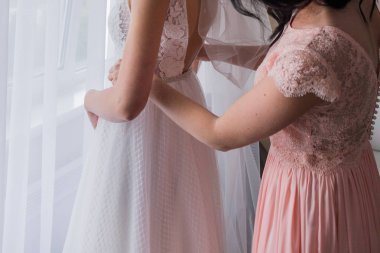 pembe elbisenin nedimesi bir ağırlıksız gelinlik koyar