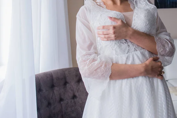 Mariée en peignoir tenant une robe de mariée — Photo