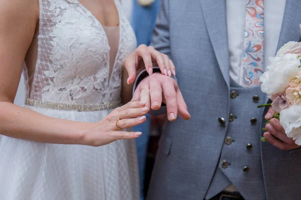 The bride and groom stand together in an embrace in the park — Stock Photo, Image