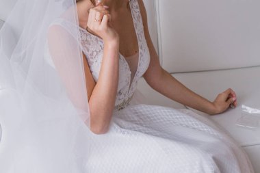 bir gelinlik içinde gelin yatakta oturuyor