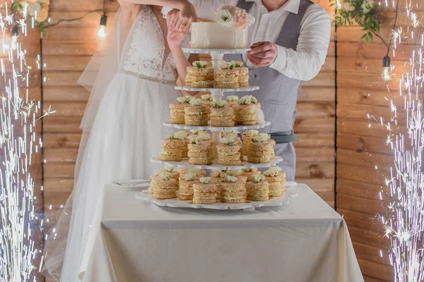 Novia y novio cortar el pastel de bodas y fuegos artificiales — Foto de Stock