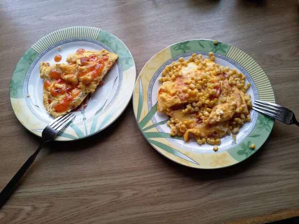 Omelette avec maïs sur les assiettes sur la table — Photo