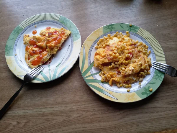 Omelete com milho em pratos na mesa — Fotografia de Stock