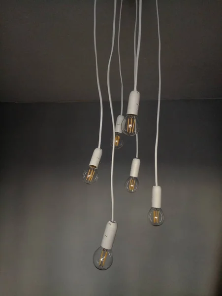 Glühbirnen hängen an Drähten von der Decke — Stockfoto
