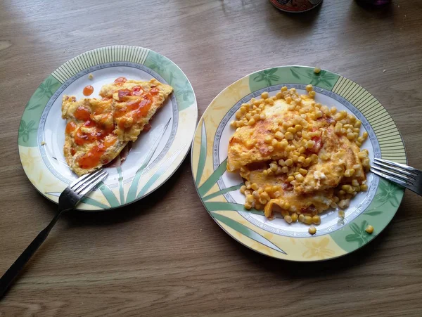 Omelet met maïs op borden op tafel — Stockfoto