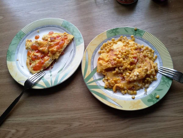 Omelet met maïs op borden op tafel — Stockfoto