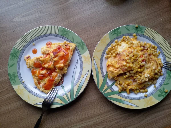 Omelete com milho em pratos na mesa — Fotografia de Stock
