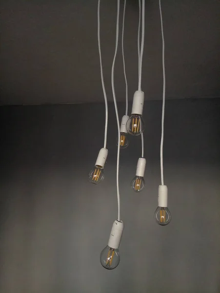 Light bulbs hanging on wires from the ceiling — Stock Photo, Image