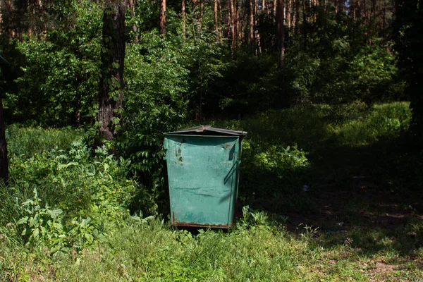 a large trash can in the forest