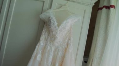 Gelin gelinliği dolapta asılı.