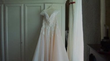 Gelin gelinliği dolapta asılı.