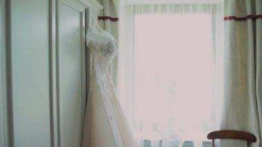 Gelin gelinliği dolapta asılı.