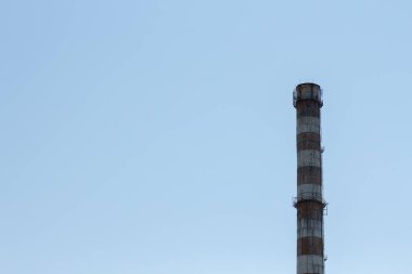 Mavi gökyüzüne karşı bir fabrika bacası.