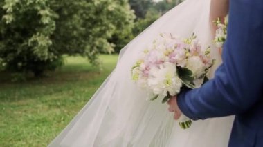 Bir gelin ve bir buket çiçekli damat.