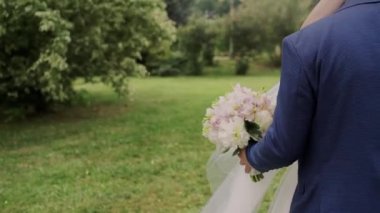 Bir gelin ve bir buket çiçekli damat.