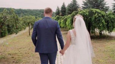Gelin ve damat İtalya 'da bir parkta yürüyorlar.