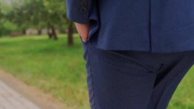 Ayakkabılı bir adam parkta yürüyor.