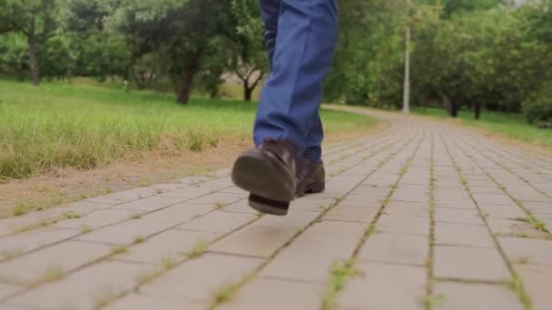 Een Man Met Schoenen Loopt Het Park — Stockvideo