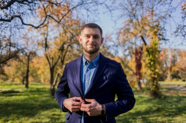 Sonbaharda parkta takım elbiseli bir adam.