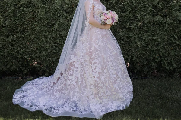 新娘穿着婚纱 带着一束鲜花在公园里 — 图库照片