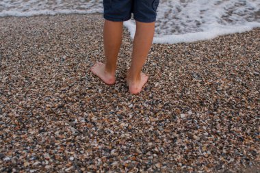 Deniz kıyısında bir çocuk ayağı