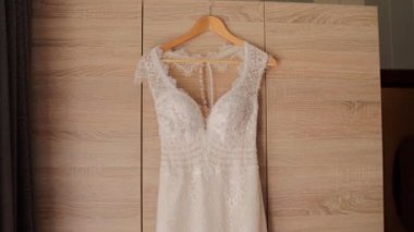 Nedime gelinliği gardıropta asılı.