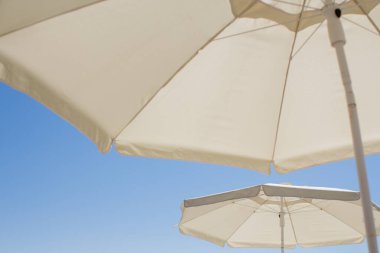 Mavi gökyüzüne karşı bir plaj şemsiyesi