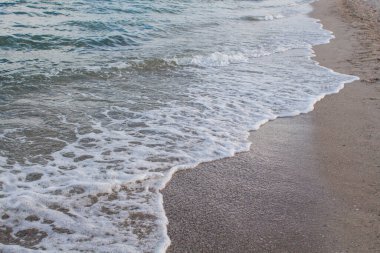 Temiz su ve gökyüzü olan bir sahil.