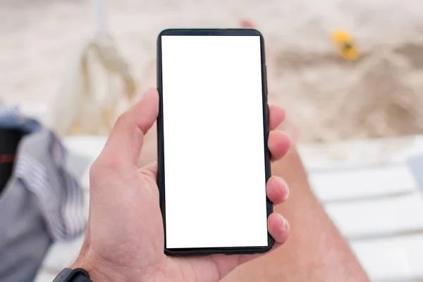Sahilde elinde bir akıllı telefon.