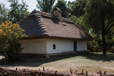 Sazdan çatılı beyaz bir Slav evi.