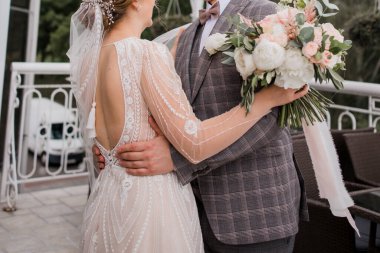 Bir damat ve gelin düğünde birbirlerine sarılıyorlar.