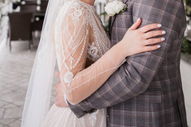 Bir damat ve gelin düğünde birbirlerine sarılıyorlar.