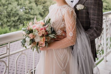 Bir damat ve gelin düğünde birbirlerine sarılıyorlar.