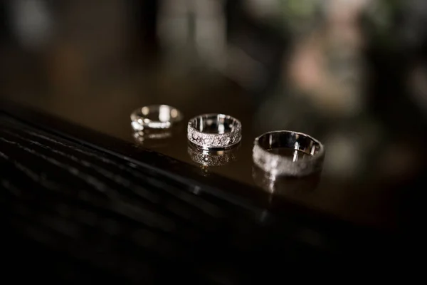 Snubní Prsteny Leží Tmavém Stole — Stock fotografie