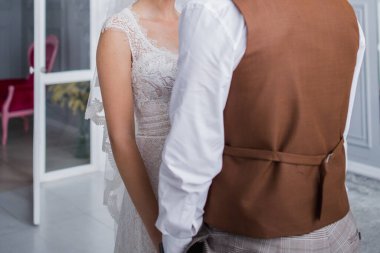 Gelin ve damat stüdyoda kucaklaşıyorlar.