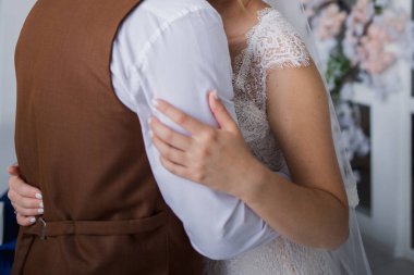 Gelin ve damat stüdyoda kucaklaşıyorlar.