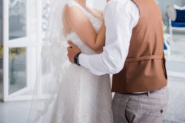 Gelin ve damat stüdyoda kucaklaşıyorlar.