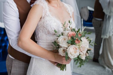 Gelin ve damat stüdyoda kucaklaşıyorlar.