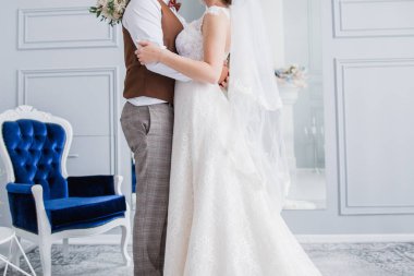 Gelin ve damat stüdyoda kucaklaşıyorlar.