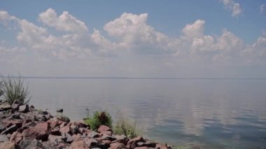 Kayalık nehir kıyısı ve bulutlu mavi gökyüzü